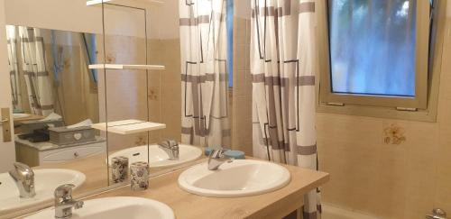 une salle de bain avec deux lavabos et un grand miroir dans l'établissement Appartement Angela, au Golfe-Juan