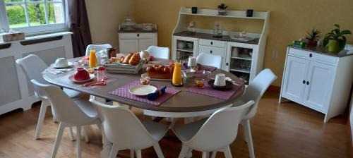 a dining room with a table and white chairs at Ker Paula in Plessala