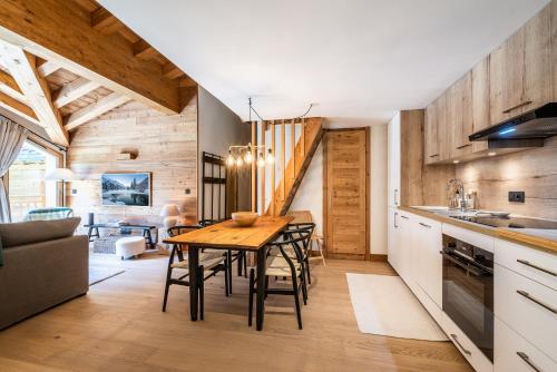 une cuisine et une salle à manger avec une table et des chaises en bois dans l'établissement Apartment Celosia Chamonix - by EMERALD STAY, à Chamonix-Mont-Blanc