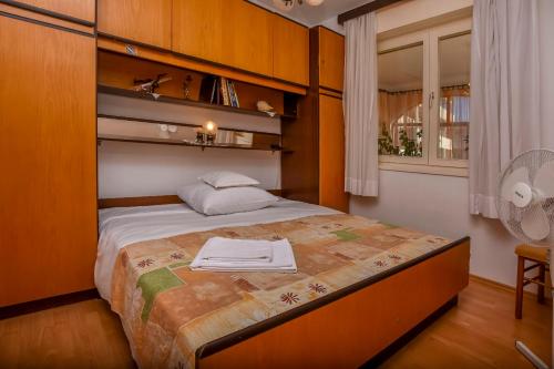 1 dormitorio con 1 cama, ventana y ventilador en Apartment Luketa, en Primošten