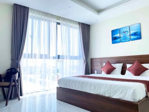 a bedroom with a bed and a large window at Hoàng Triều Hotel - Marina Bình Dương in Thu Dau Mot