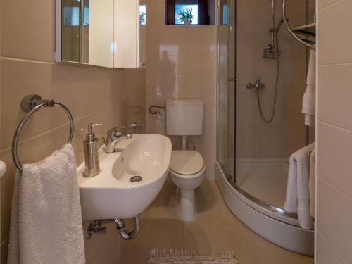 een badkamer met een wastafel, een toilet en een douche bij Villa Lara in Jadranovo