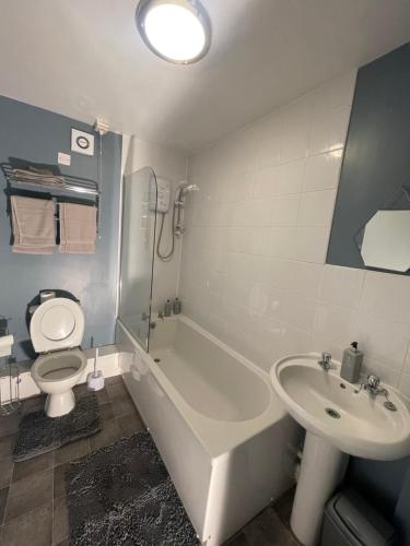 ein Badezimmer mit einer Badewanne, einem WC und einem Waschbecken in der Unterkunft Cosy, modern Apartment in Darlaston