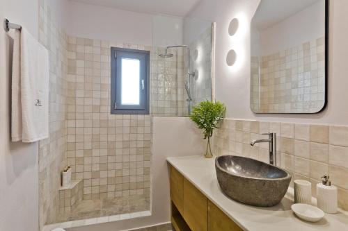 W łazience znajduje się umywalka i lustro. w obiekcie Olia Boutique Apartments w mieście Karpatos