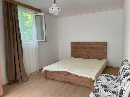 a bedroom with a bed and a chair and a window at Makas Home in Makhvilauri