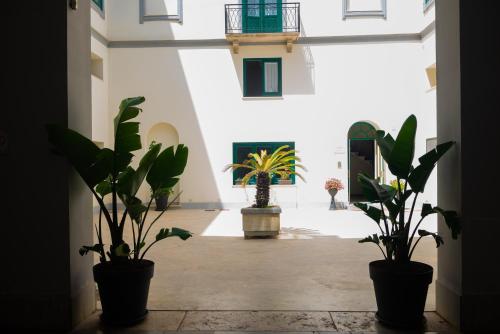 a hallway with potted plants in a building at Historico Loft & Rooms Palazzo Adragna XIX in Trapani