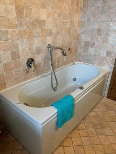 a white bath tub with a blue towel on it at Villa Panorama in Gargnano