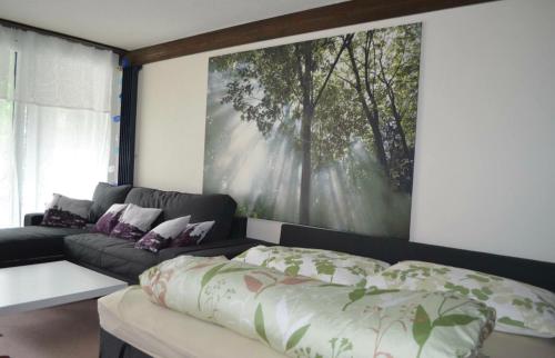 a living room with a couch and a large painting on the wall at Ferienwohnung Engelberg in Engelberg
