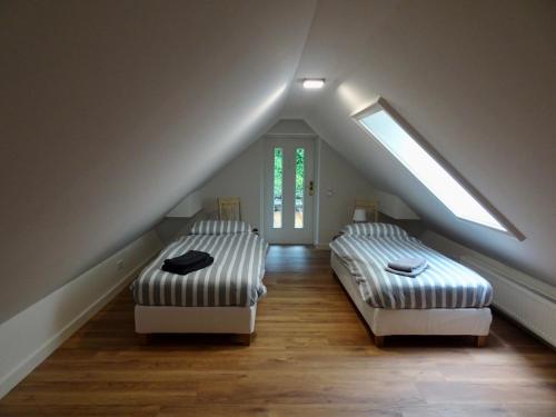 two beds in a attic room with a sloping ceiling at Ferienhaus Blommers in Palfau