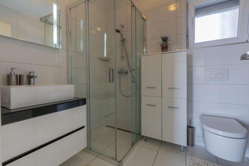 uma casa de banho com um chuveiro, um WC e um lavatório. em Apartment SAJO em Crikvenica