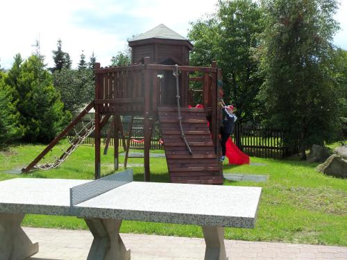a playground in a park with a girl on a swing at Ferienpension Gabriele 15 in Kurort Gohrisch