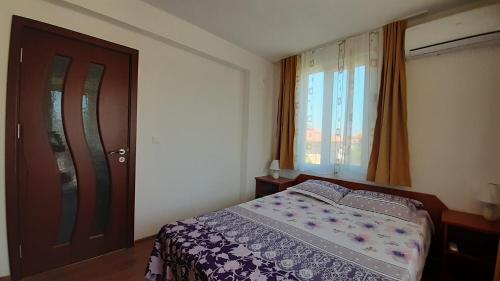 a bedroom with a bed and a window and a door at Hris in Chernomorets