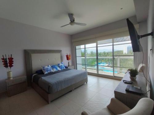 a bedroom with a bed and a balcony with a pool at Mayan Lake Horus in Acapulco