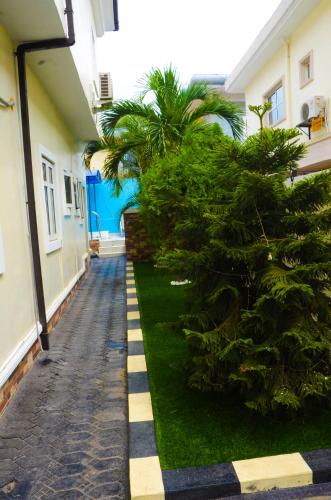 a courtyard of a house with a tree and a sidewalk at J Gibson Hotel in Lagos