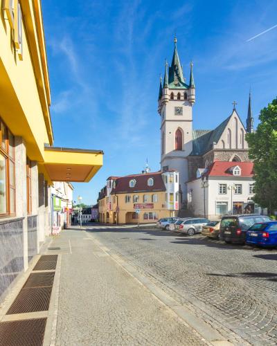 a city street with a church with a clock tower at Hotel Kotyza in Humpolec