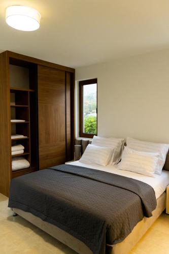a bedroom with a large bed with a window at Villa Forte Mare in Petrovac na Moru