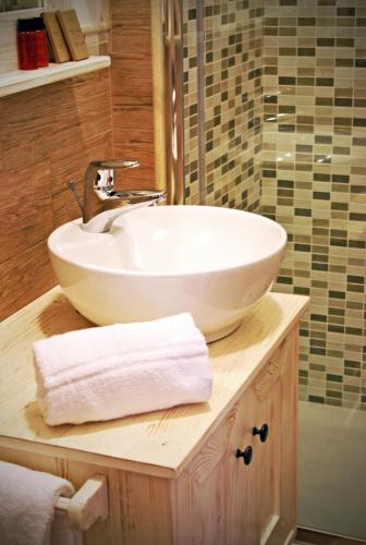 a bathroom with a white sink on a wooden counter at Fiumicino Airport B&B Deluxe in Fiumicino