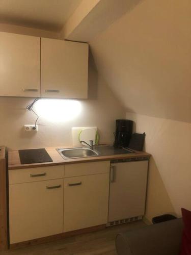 una pequeña cocina con fregadero y luz en Apartment Ballova en Balve