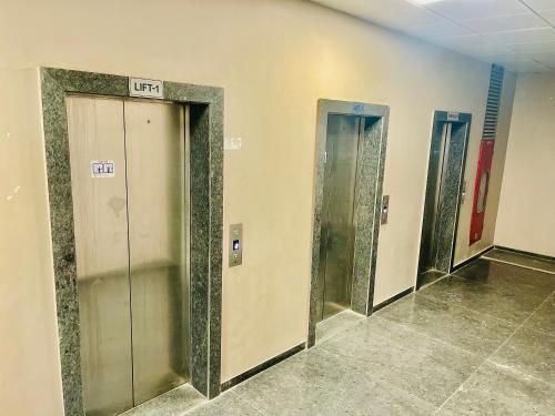 a row of elevator doors in a building at Hotel Avenue in Ahmedabad