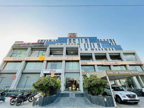 a building with a car parked in front of it at HOTEL AVENUE AC ROOMS in Ahmedabad