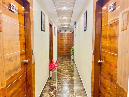 a hallway with wooden doors and a tile floor at Hotel Avenue in Ahmedabad