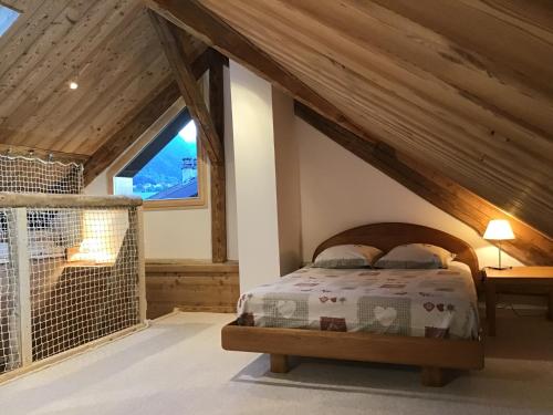 une chambre avec un lit dans un grenier dans l'établissement La cabane de Blanche entre lac et montagne, à Verchères