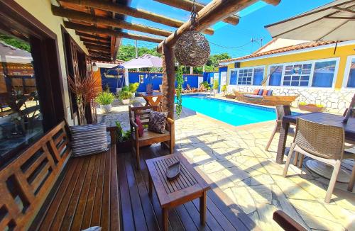 una terraza con mesa, sillas y piscina en Pousada Solar de Geribá en Búzios