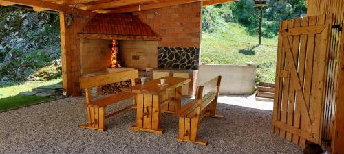 eine Terrasse mit einem Kamin, einem Tisch und einem Herd in der Unterkunft Apartma Čuvajnica in Hudajužna