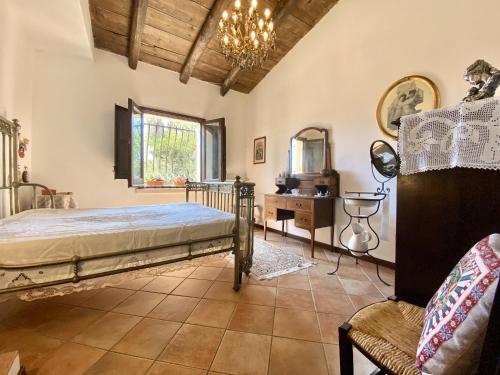 ein Schlafzimmer mit einem Bett, einem Tisch und einem Stuhl in der Unterkunft Baglio Giganti in Alcamo