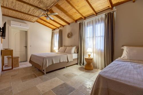 a bedroom with two beds and a large window at Lika Alacati in Alaçatı
