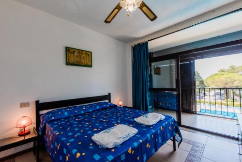 a bedroom with a bed and a large window at Residence Magnolia in Marina di Bibbona