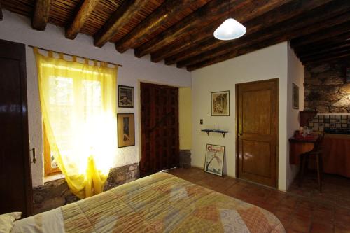 a bedroom with a large bed and a window at Casa Curtos in Real de Catorce