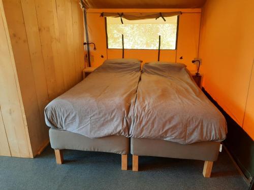 a bed in a small room with a window at casavistafiore in Montefiore dellʼAso