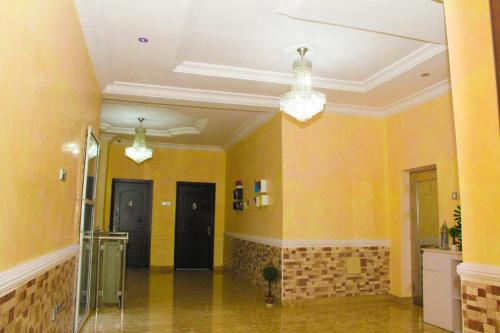 a hallway with yellow walls and chandeliers at J Gibson Hotel in Lagos