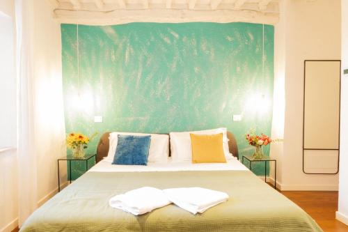 a bedroom with a bed with a green wall at Incanto b&b in Pienza