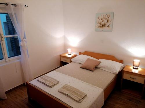 - une petite chambre avec un lit et 2 tables de chevet dans l'établissement Apartments Amfora, à Gdinj