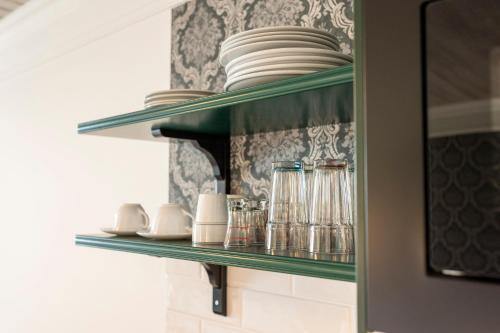 a green shelf with plates and dishes on it at Hotel Garni Keil in Kleinarl