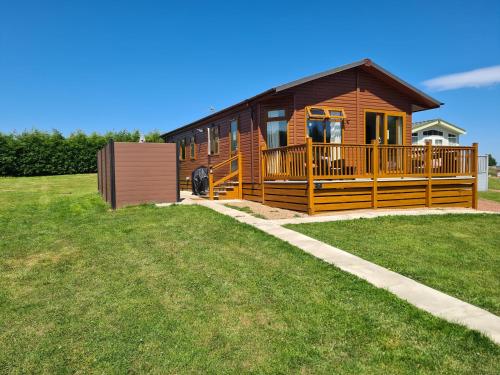 una baita di tronchi con un ampio portico e una terrazza. di Mildreds Lodge with Hot Tub a Felton