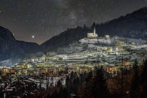 a town on a mountain at night under a star filled sky at Tiny House Dolomiti in Sovramonte