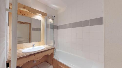 een badkamer met een wastafel en een spiegel bij Le Hameau SPA & PISCINE studio 2 pers by Alpvision Residences in Orelle