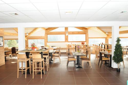 une salle à manger avec tables, chaises et fenêtres dans l'établissement Hameau 6 201a - SPA & PISCINE studio 2 pers, à Orelle
