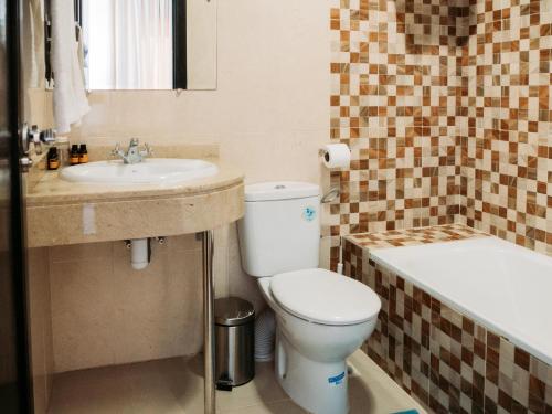 La salle de bains est pourvue de toilettes, d'un lavabo et d'une baignoire. dans l'établissement Hotel L'Aéroport, à Nador