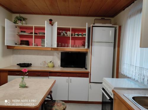 a kitchen with white cabinets and a white refrigerator at Apartma Izola in Izola