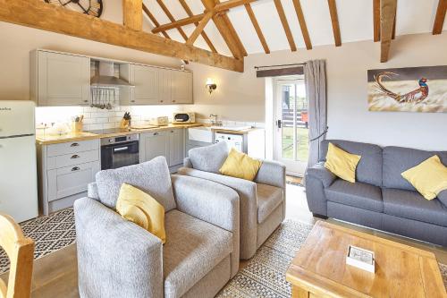 uma sala de estar com dois sofás e uma cozinha em Host & Stay - Low Waupley Farm em Liverton