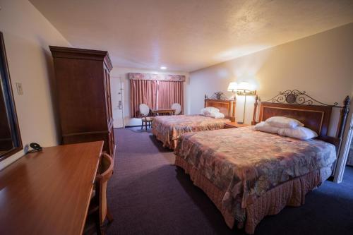 a hotel room with two beds and a table at Clover Creek Inn in Montpelier