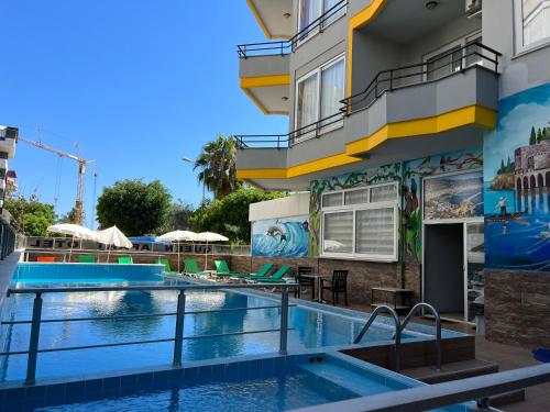 a pool at a hotel with a mural on the side of a building at Alanya Queen Apart Otel in Alanya