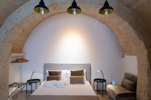 a bedroom with a bed and a couch under an arch at CASA BEATA ELIA in Bari