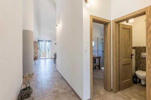 a hallway with a door leading to a bathroom with a toilet at House Villa Getaway in Mirce
