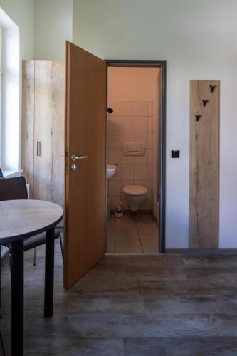 a door leading to a bathroom with a toilet at Gästehaus Dresden - Alte Schule Gohlis in Dresden