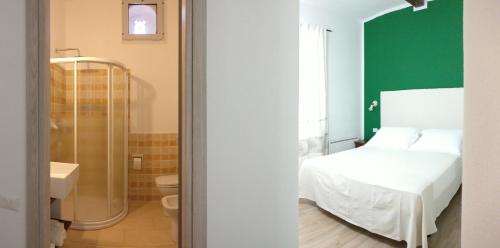 a bedroom with a bed and a bathroom with a shower at Hotel Da Cecco in Santa Teresa Gallura